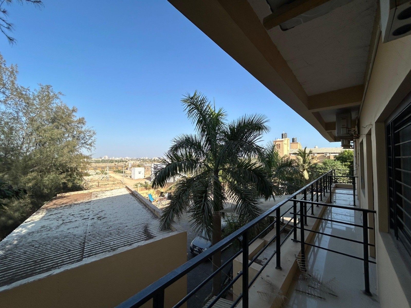 View from a first-floor balcony over palm trees