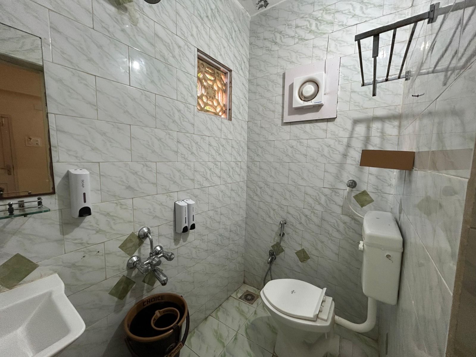 Tiled bathroom with a western toilet, a health faucet, a tap and an exhaust fan