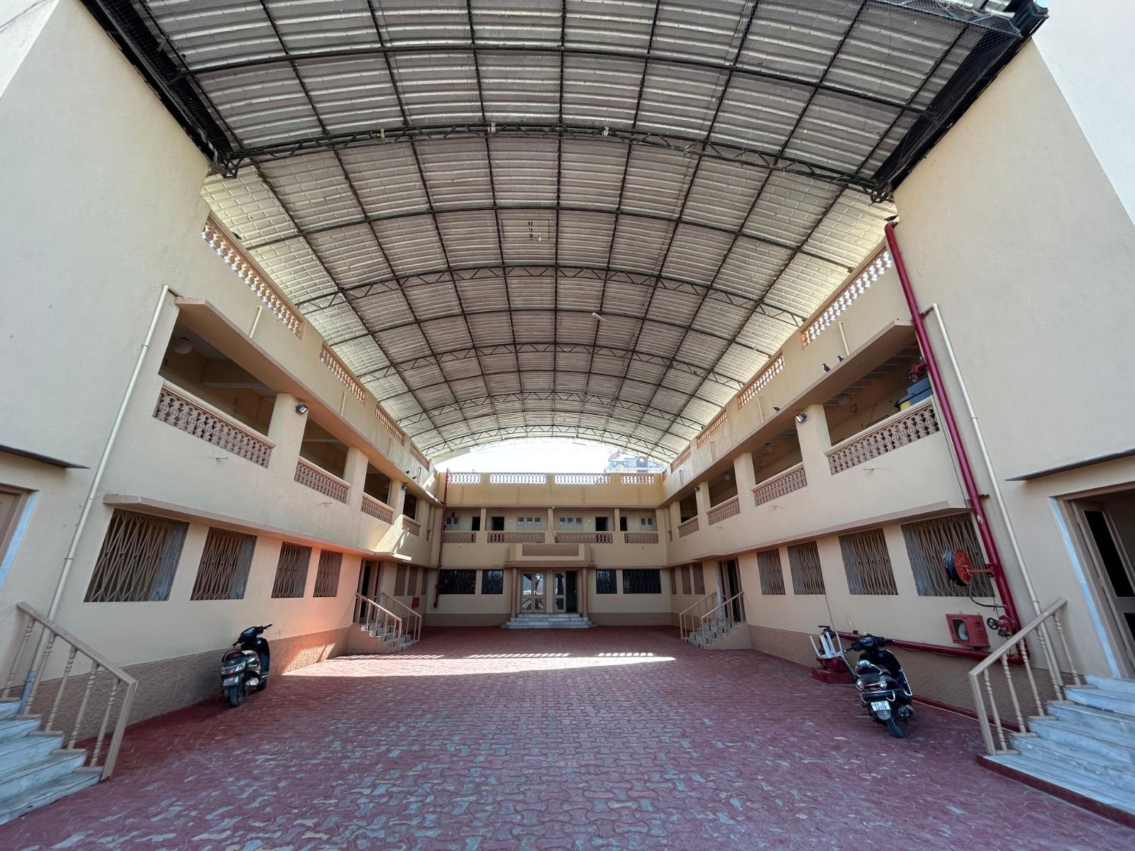 Covered courtyard with a curved roof, between two floors of rooms