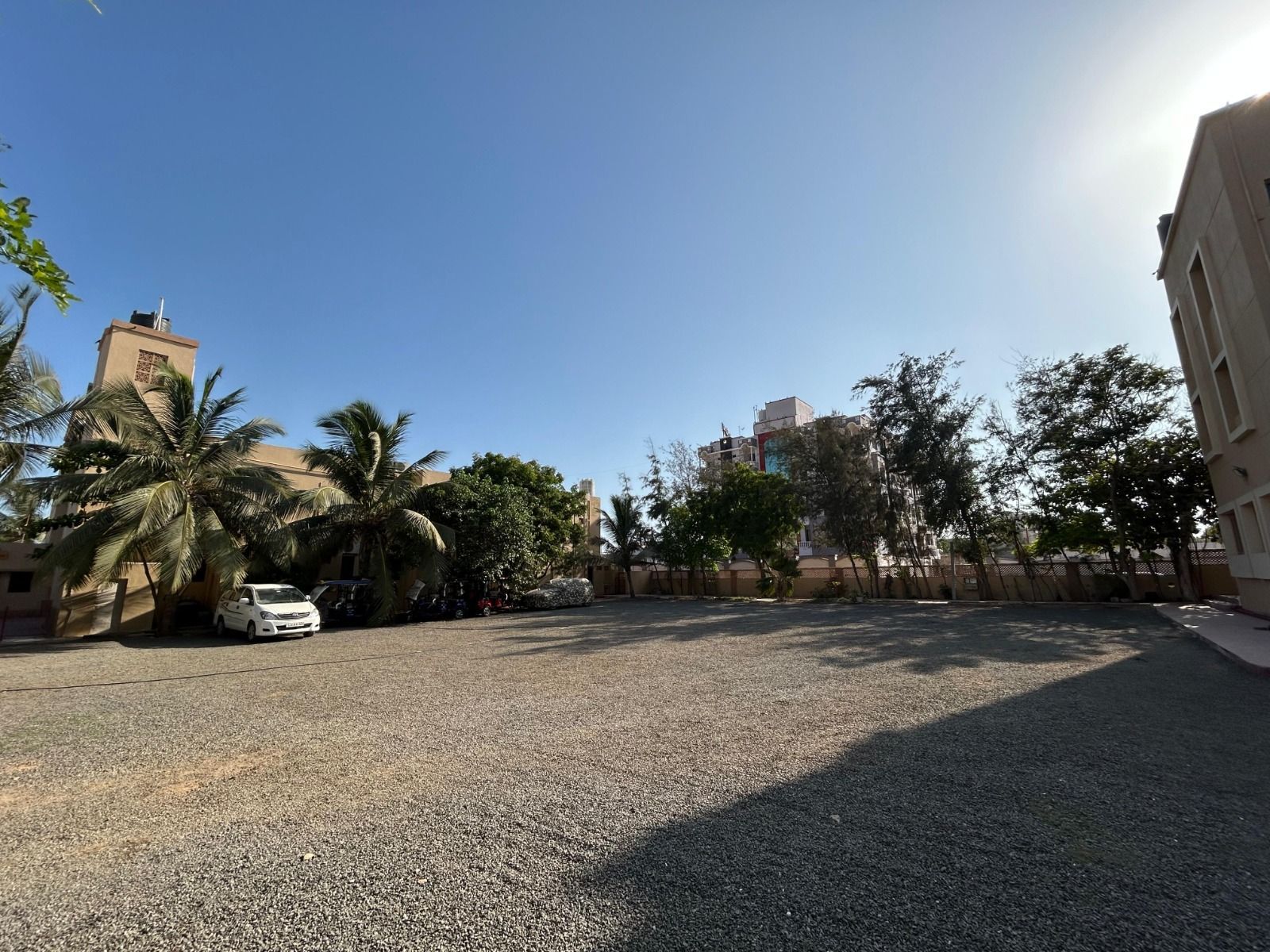 Open ground with cars parked under the trees
