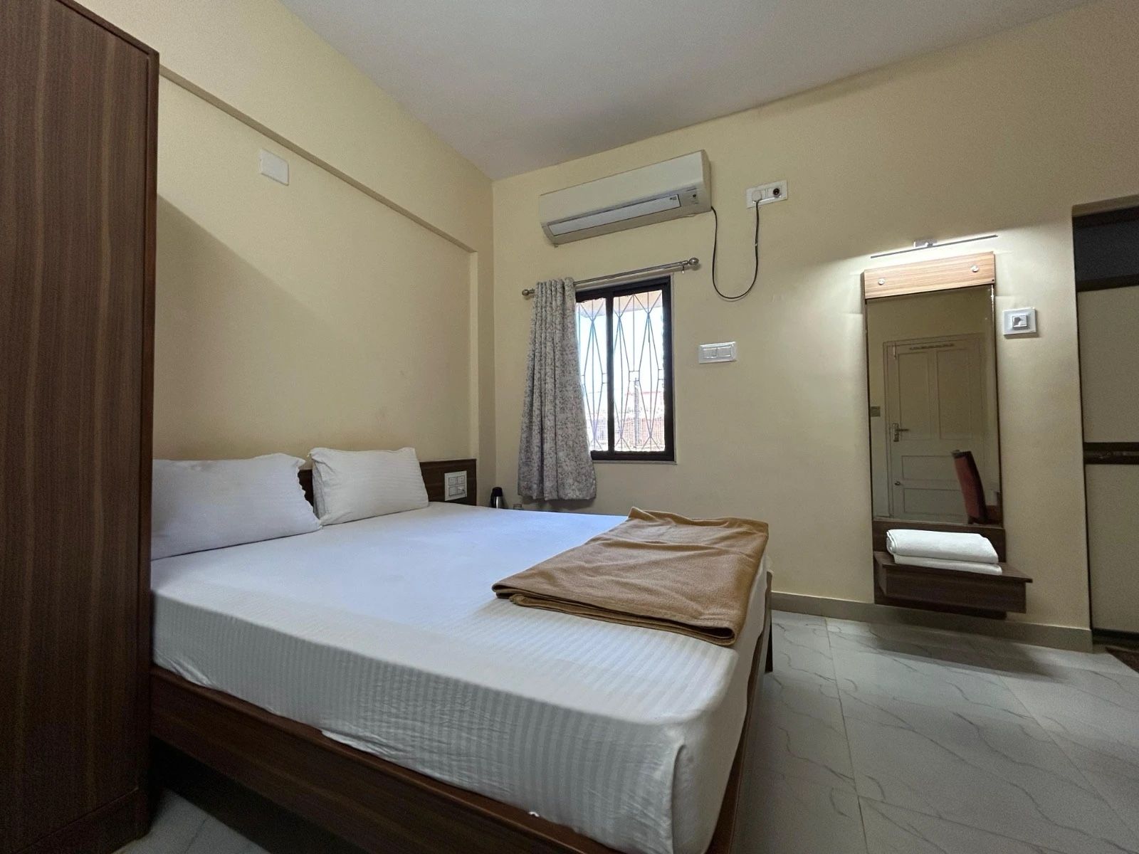 Deluxe 2-Bed AC room with a double bed, a wardrobe, a mirror and a split AC
